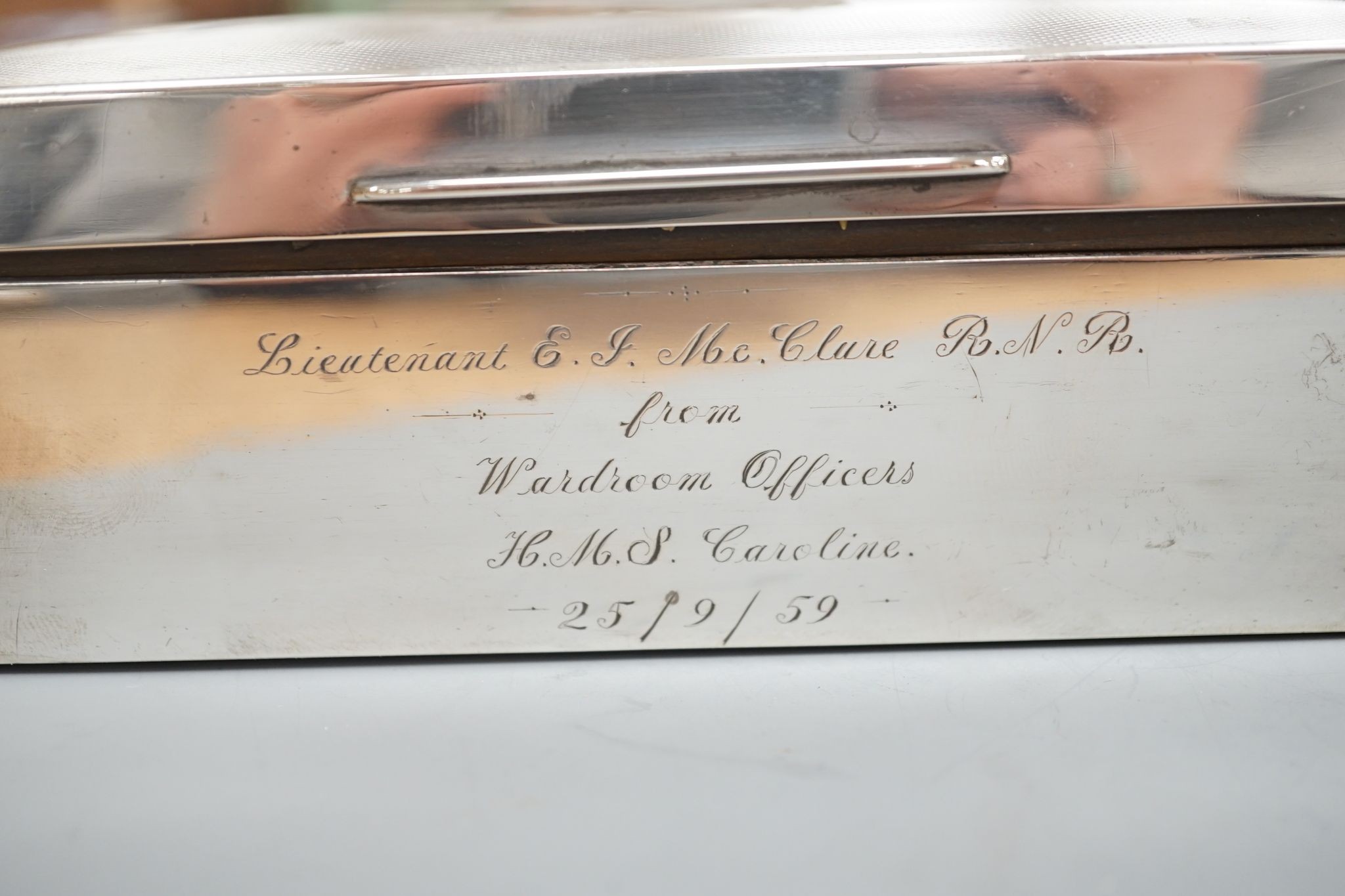 A late 1950's engine turned silver mounted rectangular cigarette box, with engraved inscription, 17.8cm.